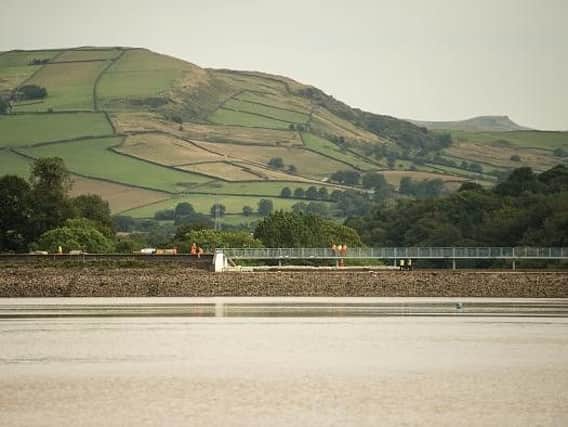 Engineers and members of the emergency services asses the damaged spillway of the Toddbrook Reservoir. Photo: OLI SCARFF/AFP/Getty Images.