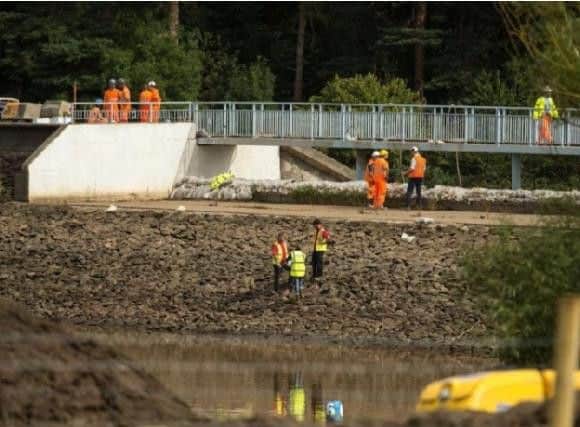 Engineers and members of the emergency services work to pump water from Toddbrook Reservoir. Photo: Oli Scarff/AFP/Getty Images.