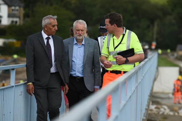 Jeremy Corbyn and a member of the emergency services at Toddbrook Reservoir. Photo OLI SCARFF/AFP/Getty Images