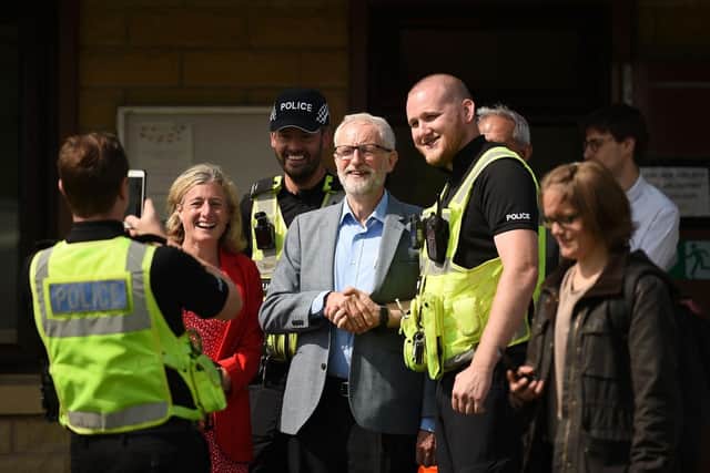 Jeremy Corbyn and High Peak MP Ruth George pose for a photograph with police officers at Toddbrook Reservoir. Photo - OLI SCARFF/AFP/Getty Images