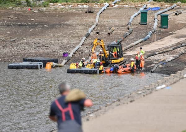 WHALEY BRIDGE, ENGLAND - AUGUST 05: Fire and Rescue service personnel place sandbags against the dam wall as as work continues to drain and shore up the damaged dam on August 5, 2019 in Whaley Bridge, England. Approximately 1,500 residents of the town's 6,500 population were forced to leave their homes after yesterday's partial collapse of the dam at Toddbrook Reservoir, in Derbyshire. Engineers have been pumping water from the reservoir overnight to reduce the water level. (Photo by Anthony Devlin/Getty Images)