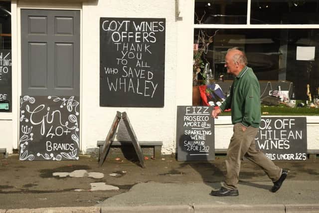 A man walks past Goyt Wines and its message to everyone who helped the Whaley Bridge community. Photo: OLI SCARFF/AFP/Getty Images.