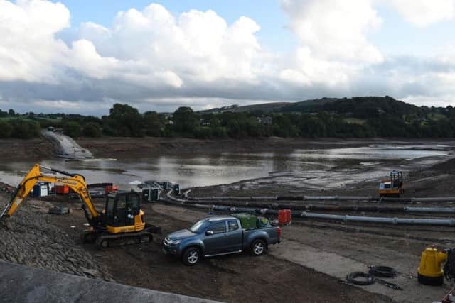 Engineers work to channel water out of Toddbrook Reservoir. Photo: OLI SCARFF/AFP/Getty Images.