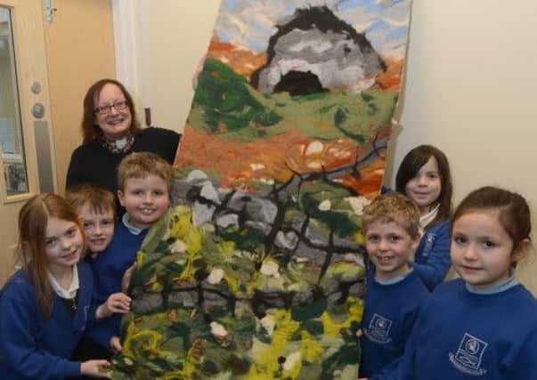 Manifold Primary, Rev Annie Ballard helps children from Owls class unveil one of three new textile artworks