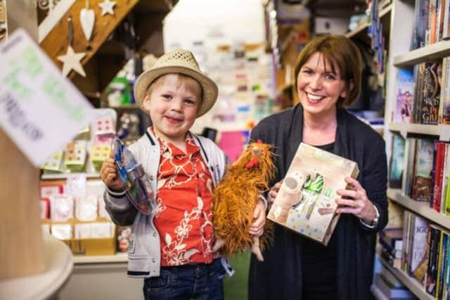 Joe Kidd receiving his prizes as the winner of the Totally Locally Easter Egg Hunt from Baytree Books owner Sarah Woolley. Photo by Adrian Lambert.