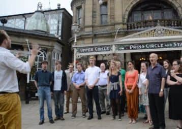 The cast of The Sorcerer perform outside Buxton Opera House.