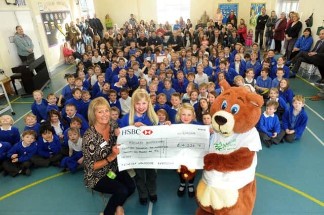 Ruby gets help from her sister Kitty with handing over the huge  cheque to Ashgate Hospicecare fundraiser Lynn Jones and Ashley Bear at her Longstone school.