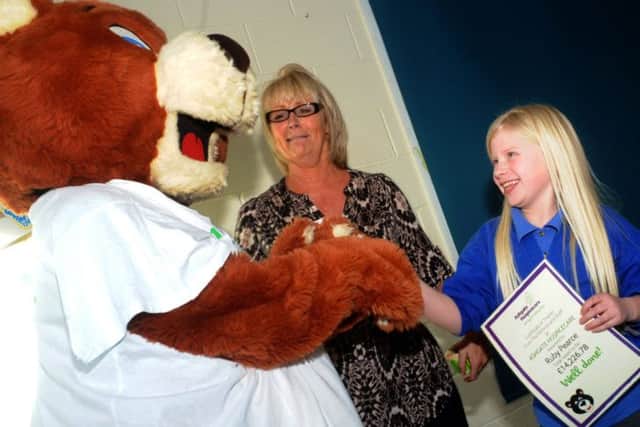 Ruby is presented with a certificate to mark her fundraising efforts.