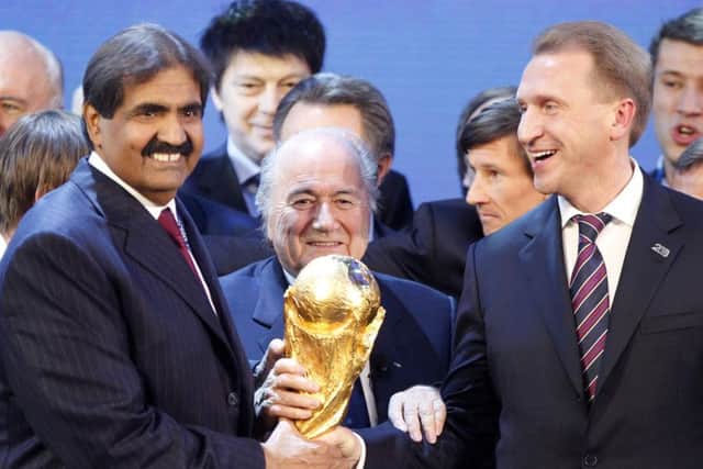 FIFA President Sep Blatter is flanked by Russian Deputy Prime Minister Igor Shuvalov, right, and Sheikh Hamad bin Khalifa Al-Thani, Emir of Qatar, after the announcement that Russia will host the World Cup 2018 and Qatar 2022.