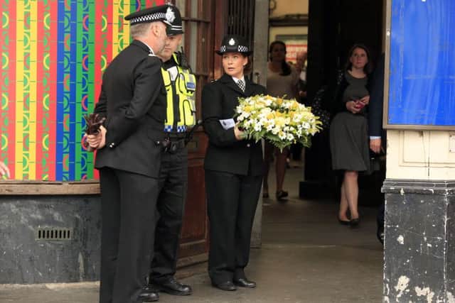 7/7 survivor Gill Hicks and other mourners arrive with flowers at Russell Square tube station, London, as Britain remembers the July 7 attacks