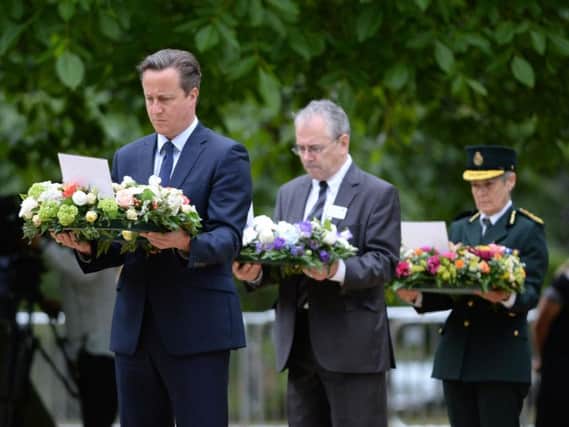 Prime Minister David Cameron, Transport Commissioner Sir Peter Hendy and Dr Fiona Moore, Chief Executive of London Ambulance, carry wreathes at the July 7 memorial in Hyde Park, London, as Britain remembers the July 7 attacks amid a welter of warnings about the enduring and changing threat from terrorism a decade on.