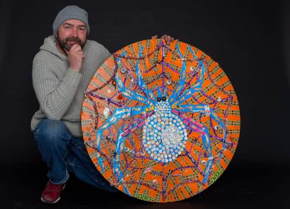 Artist Mark Kennedy alongside a spider mosaic made completely from sweets from Swizzels' Halloween range. Photo by Dave Thompson/Route One Photography.