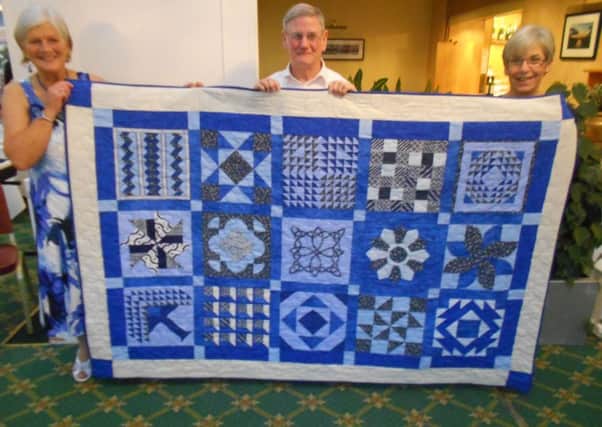 Robyn Harding, Dan Blunt and Penny Taylor with quilt made by the patchwork group of Buxton and District U3A
