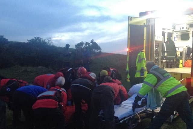 Team members transfer a casualty at Dane Valley to the care of an ambulance crew. Credit: Buxton MRT.
