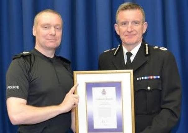 Sergeant Trevor Steed getting an award from Chief Consatble Mick Creedon for tackling a knifeman in Buxton