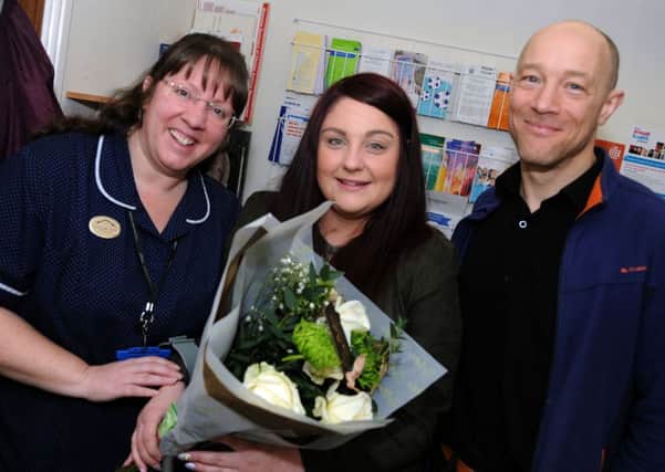 Frances Garrington visits the Stewart Medical Centre with flowers and chocolates for practice nurse Caroline Hince and Dr. Justin Walker.
