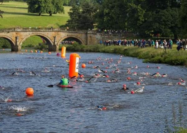 STUNNING BACKDROP -- the swimming leg in the River Derwent gets the Peak District Triathlon under way at the Chatsworth Estate.