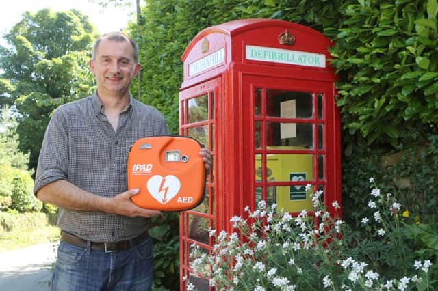 Coun Richard Bennett with the new defibrillator which is fitted in Thornhill's phone box.