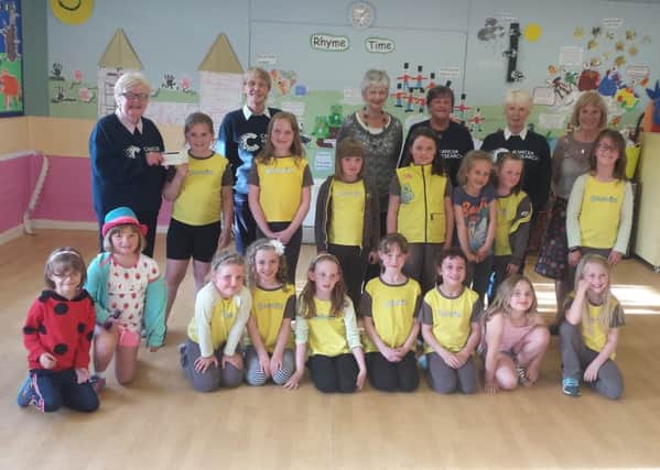 Harpur Hill Brownies hand over a cheque raised from their pantomime performance. Photo contributed.