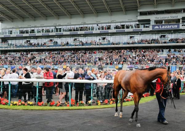 LEGER LOVE-IN -- the packed stands at Doncaster on Saturday when more than 25,000 flocked to Town Moor to see a dramatic Ladbrokes St Leger.