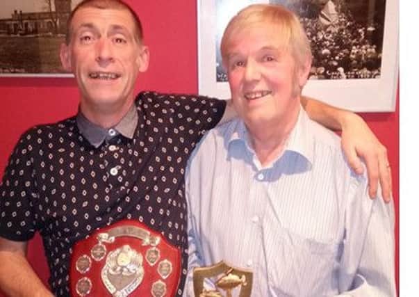 Kevin Johnston (Cosh) receives the Paul Wallis Memorial Shield and trophy from Pete Wallis, right.