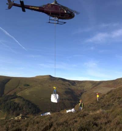 A helicopter delivers bags of stone to Kinder Scout to help repair badly-eroded footpaths. Photo: Rod Kirkpatrick/F Stop Press.