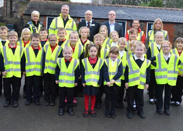 PCSO Karen Green, High Peak borough councillor Jim Perkin, local councillor Daren Robins, Hayden Gill, Production Manager at Cemex and resident Leanne Wild with children from Dove Holes Primary School.