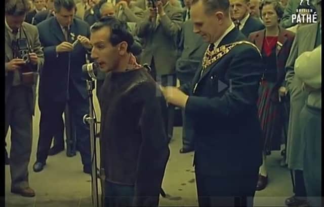 Alan Alan being tied into his straight jacket by the mayor of Buxton in 1959