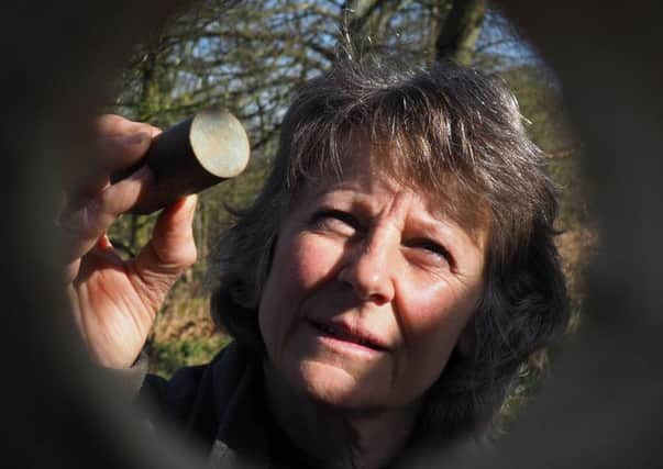 Volunteer ranger Angela Pilcher checking the size of a nest 'cork' against the hole of a kit nest box. Photo: National Trust/David Bocking.