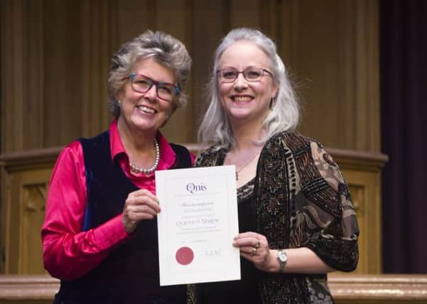 Clare Stiles (right) receives her award from TV presenter Prue Leith. Photo: Lesley Martin courtesy of QNIS.
