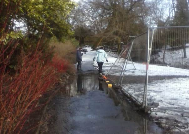 The flooded pavement alongside the River Wye in Buxton's Serpentine Park.