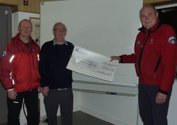 Errwood Fly Fishing Club vice-chairman Gordon Booth presents cheque to Buxton Mountain Rescue Team members Allister Legget and Joe Ree.