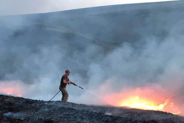 A gamekeeper battles the blaze on Goyt moor.